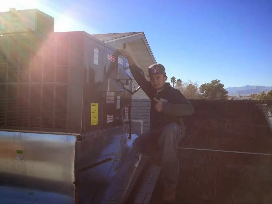 HVAC technician performing Boiler Repair on a rooftop unit in Forest Lake